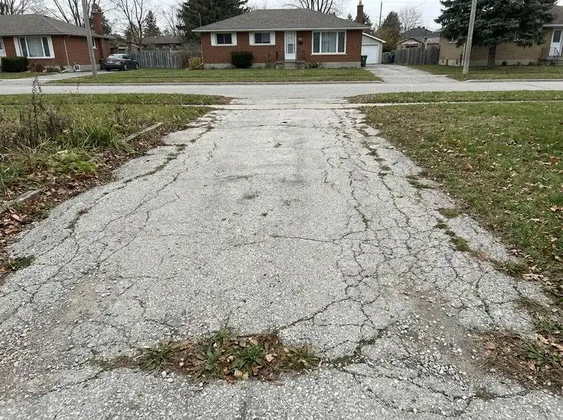 Cracked faded asphalt driveway before sealing
